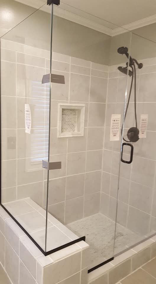 Frameless corner shower enclosure with built-in bench