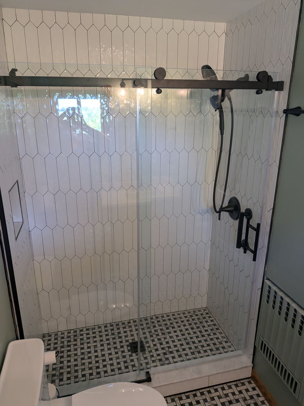 Frameless sliding shower door with matte black hardware